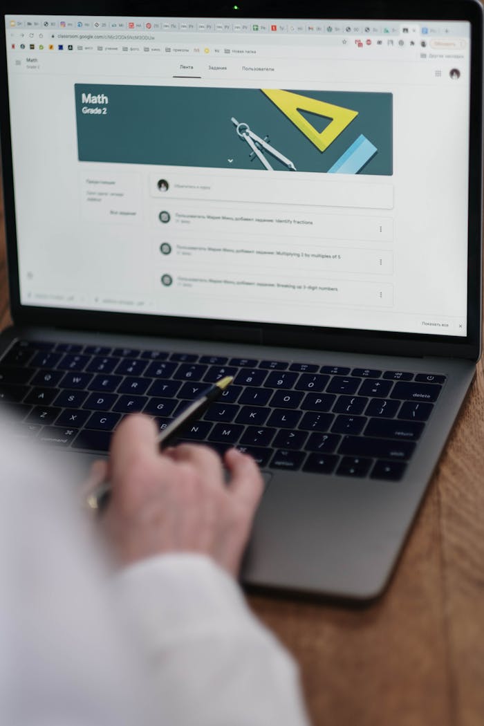 Adult using laptop for online Grade 2 math class, focusing on digital learning tools.